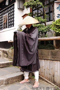 在京都-產寧坂遇到一位托缽化緣的出家人，站定路邊，帽沿低垂，不動如山，有深不可測的感覺。