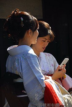 穿著傳統和服使用行動電話的年青美女